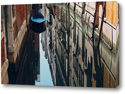    Лодка и отражение домов в воде канала в Венеции