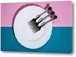    Три вилки на белой тарелке на цветном фоне